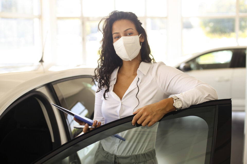 Car saleswoman with a mask on in a dealership