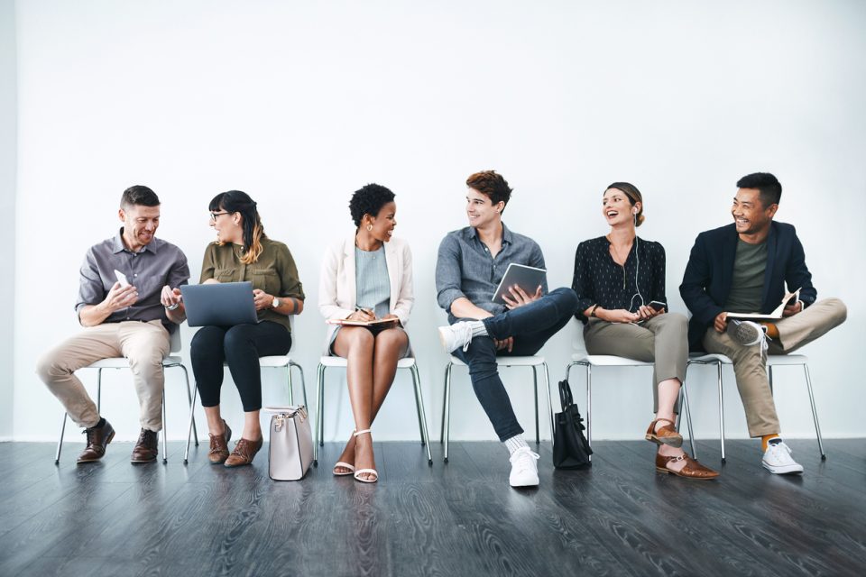 Studio shot of a group of businesspeople chatting in a waiting room